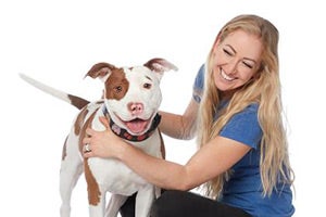 Volunteer Victoria Vertuga posing with a pit bull terrier