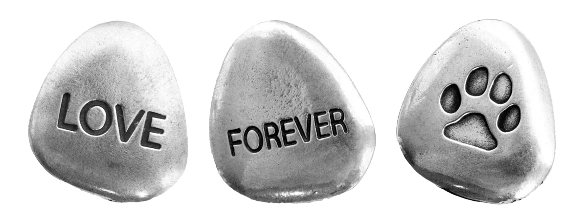 Three memorial stones: one has "love" written on it, one has "forever" written on it, and one has a paw print on it