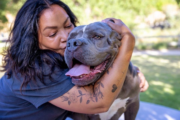 A woman hugging a big dog