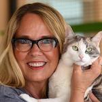 Julie castle holding a muted tortie cat