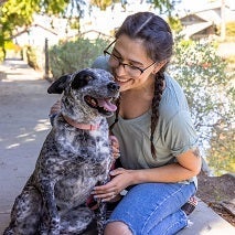 Woman sitting outside with black and white dog