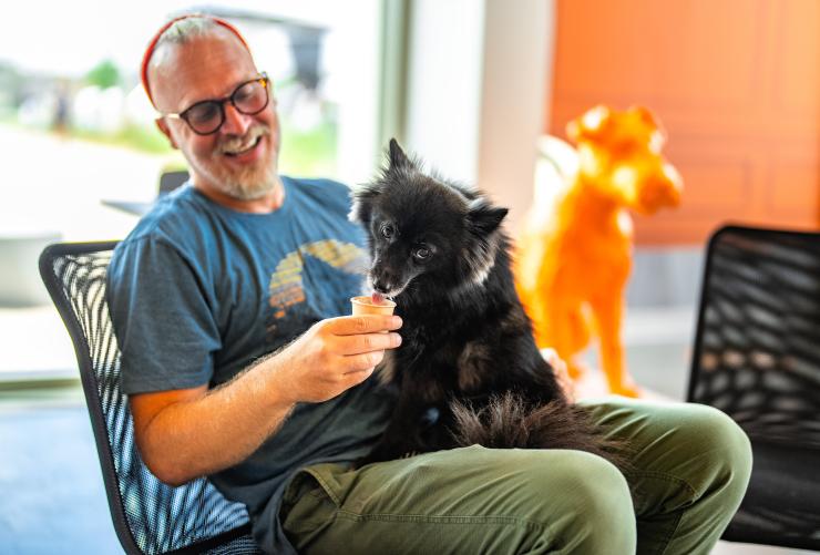 Smiling person giving a dog an ice cream cone at the Best Friends Pet Resource Center in Bentonville Arkansas