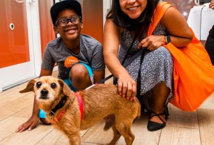 Two smiling people with a dog at Best Friends Pet Adoption Center in New York City