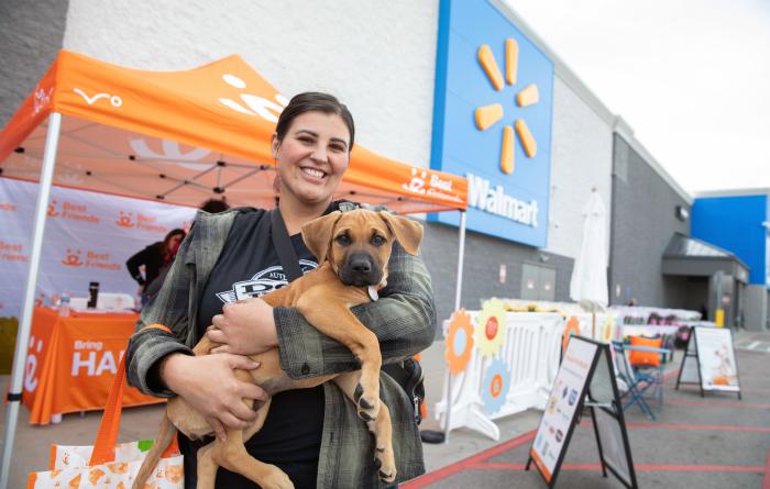 Person holding a puppy in front of the Best Friends canopy in front of Walmart in Salt Lake City