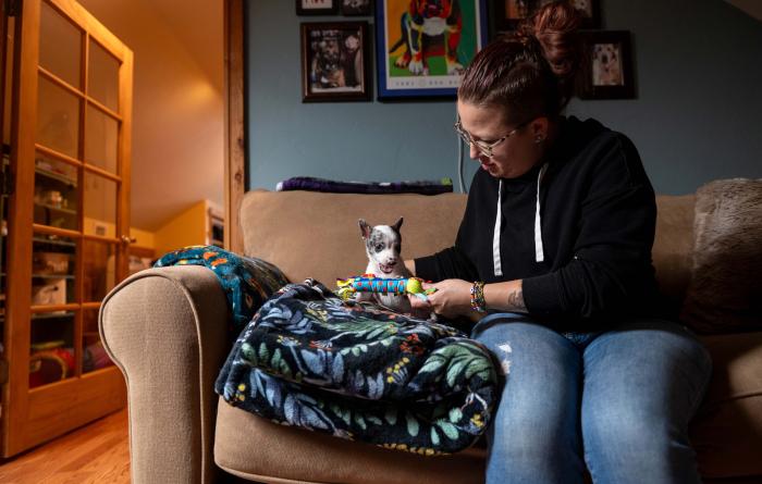 Polly Pocket the puppy and Jessica sitting on a couch with a dog toy