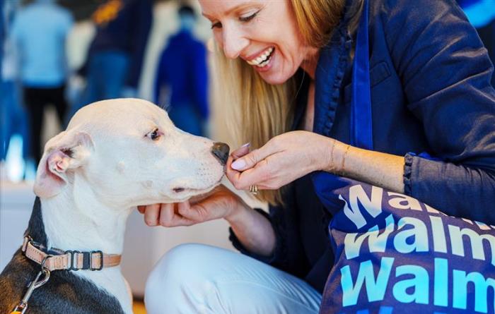 Smiling person with a Walmart bag petting a dog