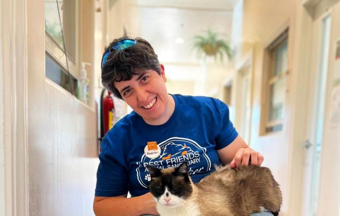 Best Friends volunteer in a wheelchair with a cat in her lap