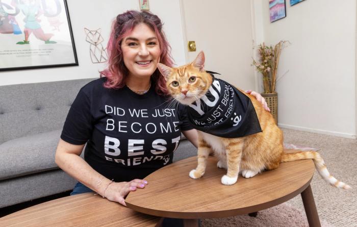 Smiling person wearing a Best Friends T-shirt that coincides with a bandanna a cat is wearing