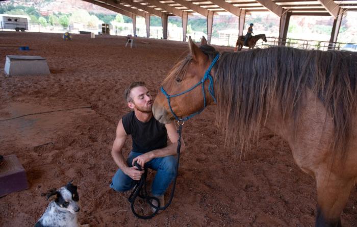 Equine trainer Christian Mathews kissing the nose of Byron the horse
