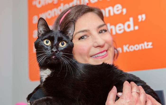 Samantha Bell holding a black and white cat