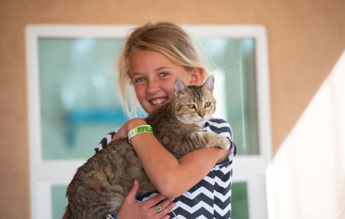 Young volunteer smiling and holding a cat