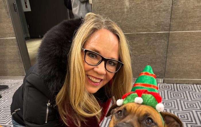 Best Friends CEO Julie Castle with a dog earing an elf outfit