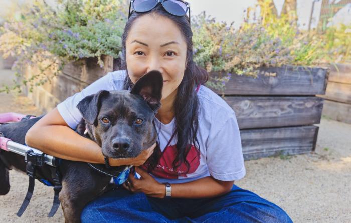 Ranko Fukuda hugging Kody the dog, who is in her wheelchair