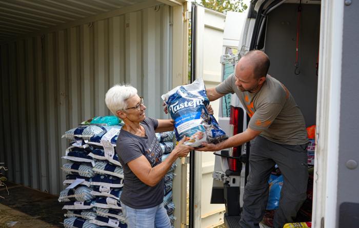 People unloading a bag of pet food from a transport truck