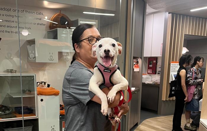 Person holding a happy white dog at the Best Friends Lifesaving Center in New York City