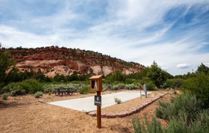RV site with a backdrop of red rock cliffs and blue sky