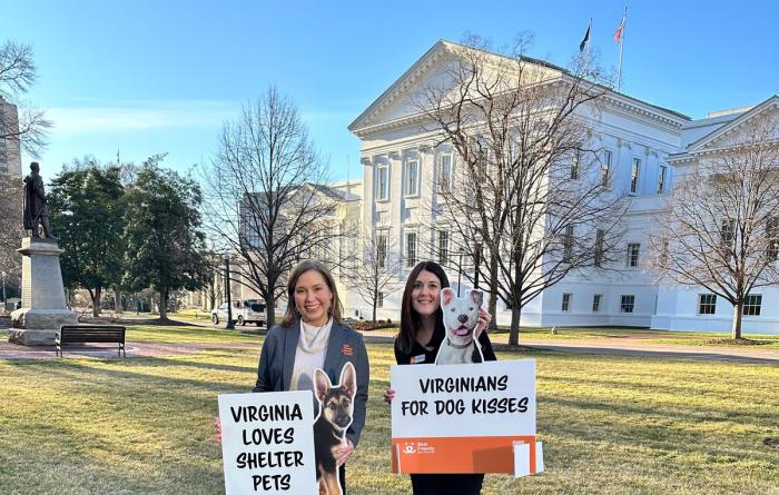 Two people with signs outside the Capitol in Richmond, Virginia