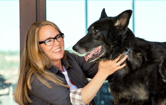 Best Friends CEO Julie Castle petting a large black shepherd