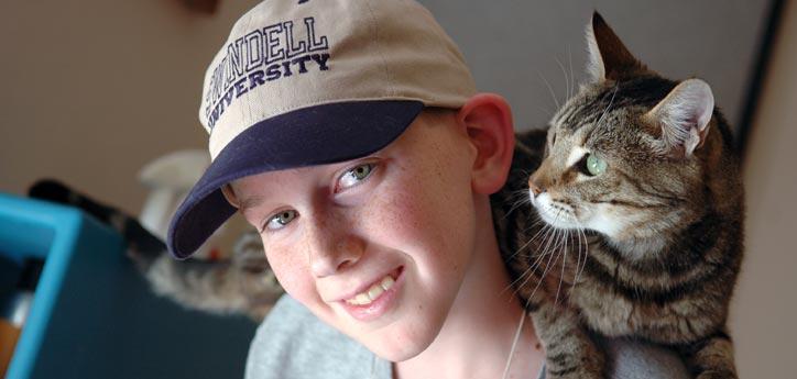 This boy and his family are fostering this sweet brown tabby cat.