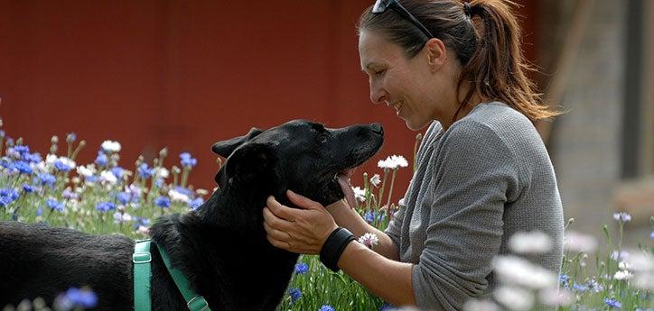 Woman with black dog who has special needs, who is covered under pet insurance to help with his vet bills