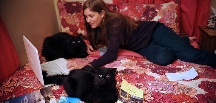 This girl (with help from her two black cats) is writing an essay on animals for school.