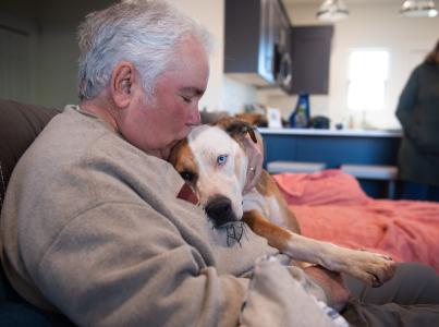 Person relaxing on a couch with a dog