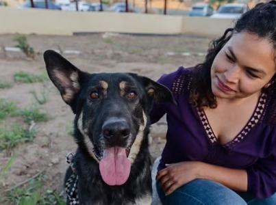 Woman sitting outside with a dog.