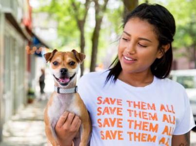 Smiling person holding a small dog