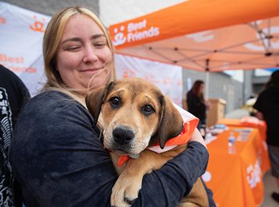 Person holding a brown puppy at a Best Friends adoption event at Walmart