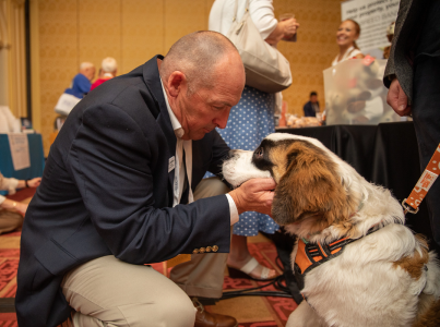 Man at an event with a brown and white dog