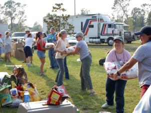 Line of people moving bags of pet food into a trailer for Hurricane Katrina rescue efforts