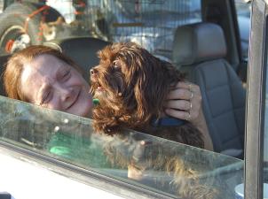 Woman and dog in a car after they were reunited following Hurricane Katrina
