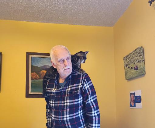 Eeyore the cat lying on Allen Burkhart's shoulder