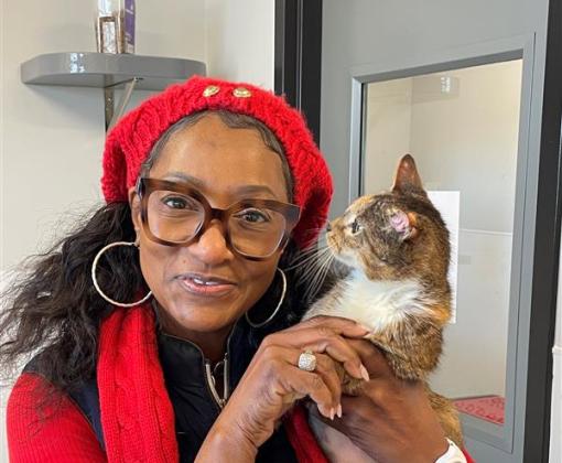 Person wearing red and holding a calico cat