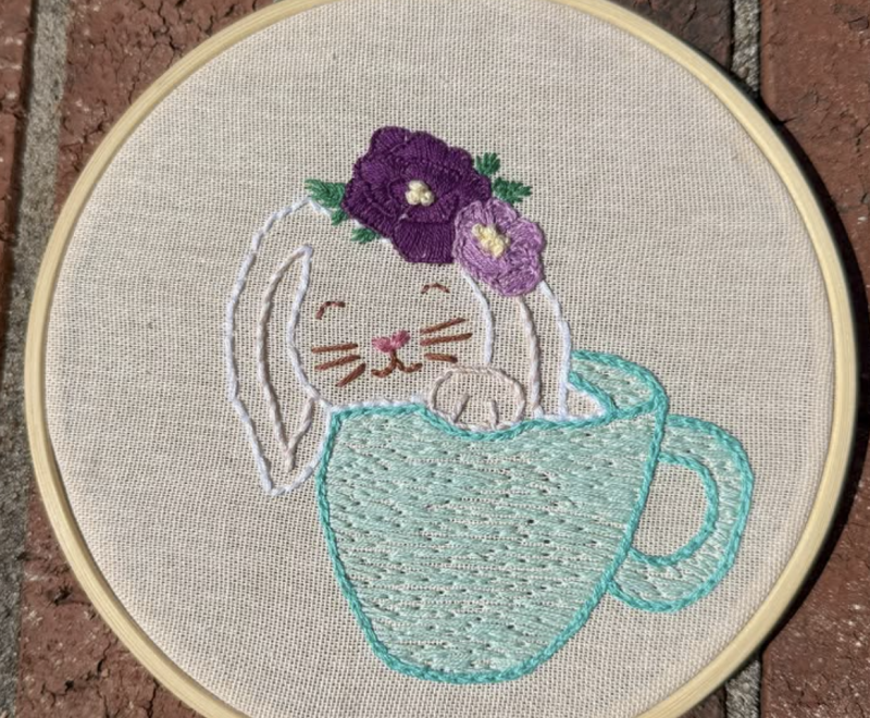 An embroidery hoop with an embroidered rabbit 