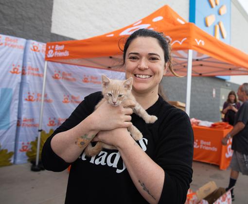 Person holding a kitten in front of a Walmart