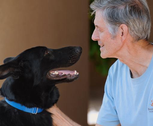 Gregory Castle kneeling down to pet a dog