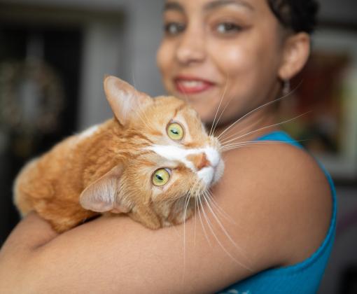 Smiling person holding a cat