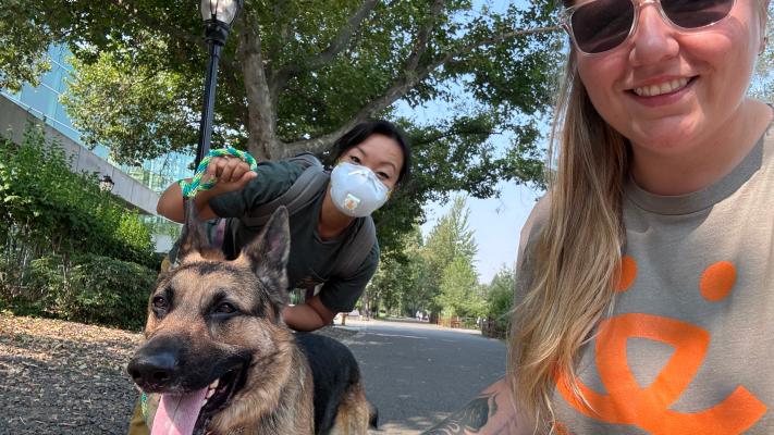 Person wearing a Best Friends T-shirt next to a person wearing a mask and a shepherd dog