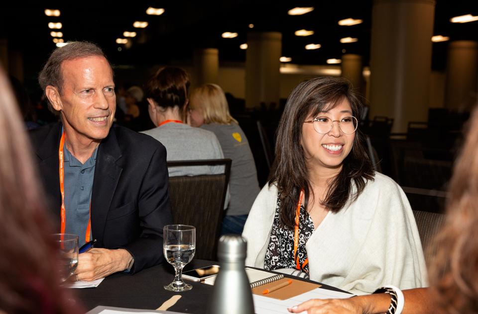 Two smiling people seated next to each other at a table