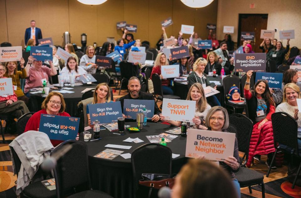 Attendees of Bring No-Kill Home Summits holding up signs.