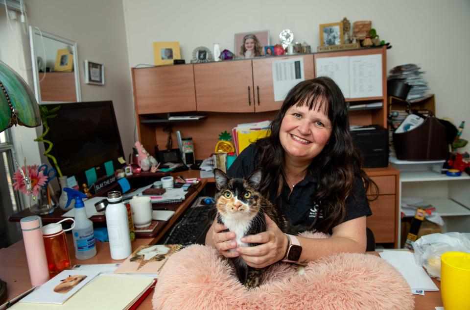Carragh Maloney at a desk with a calico cat