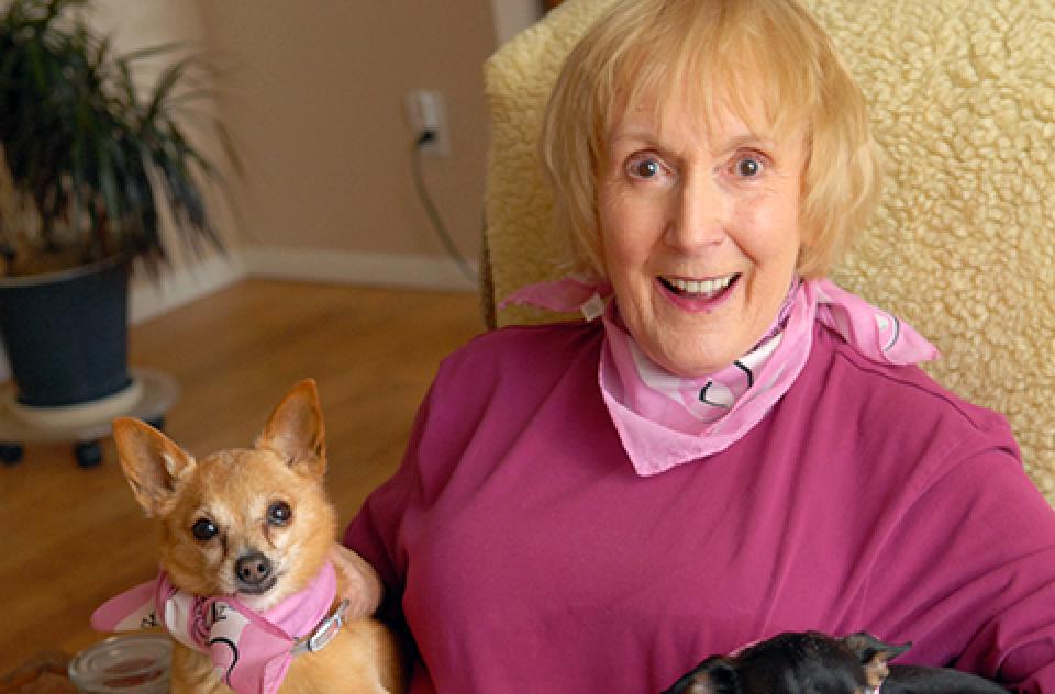 Co-founder Charity Rennie sitting in a chair with three small dogs