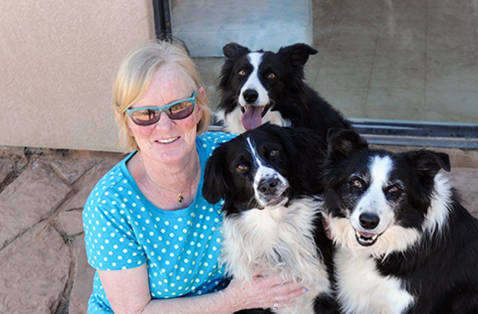 Diana Asher with three black and white dogs