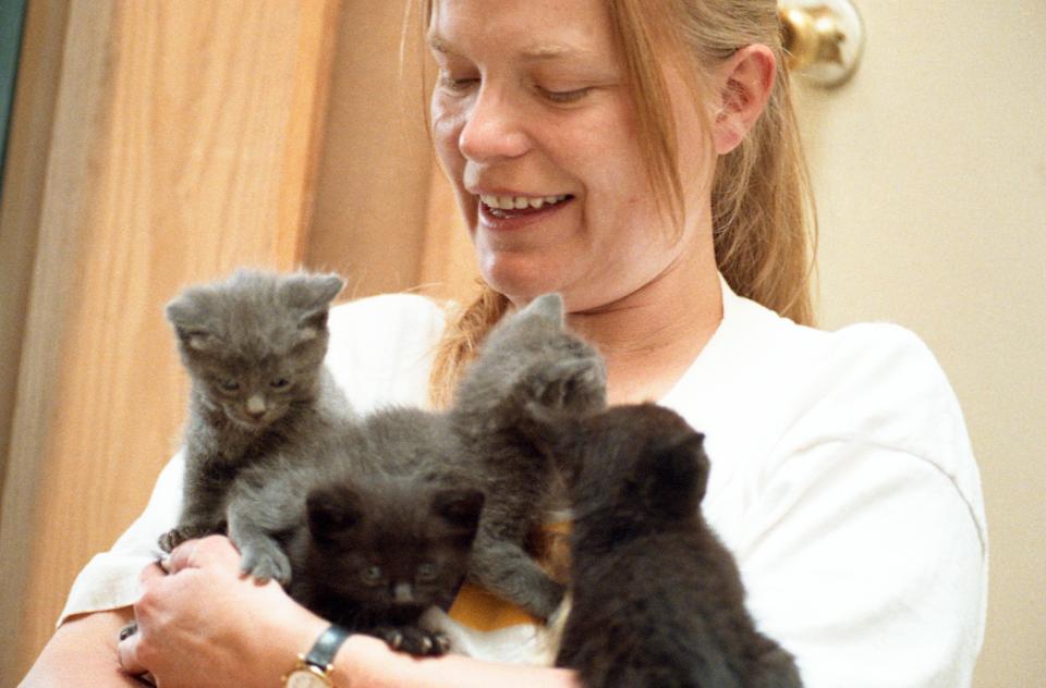 Vivian Ebbs holding a litter of kittens