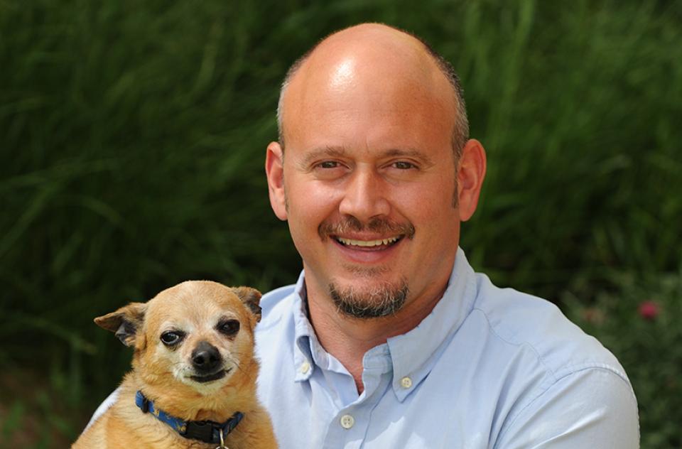 Judah Battista holding a small brown dog