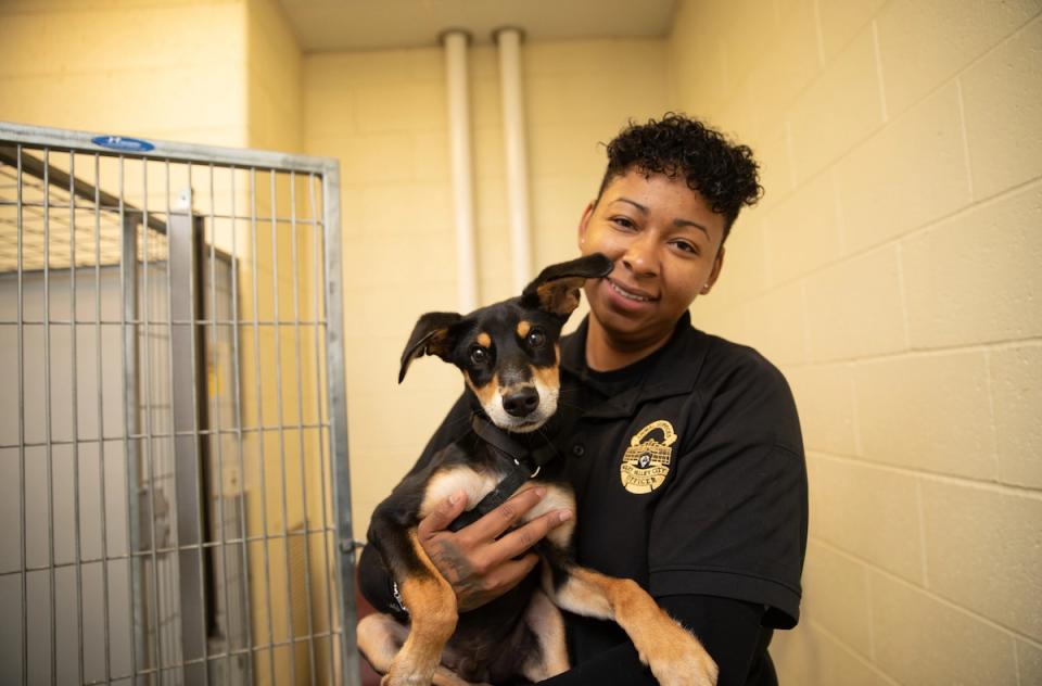 Black female ACO holding a black and brown dog