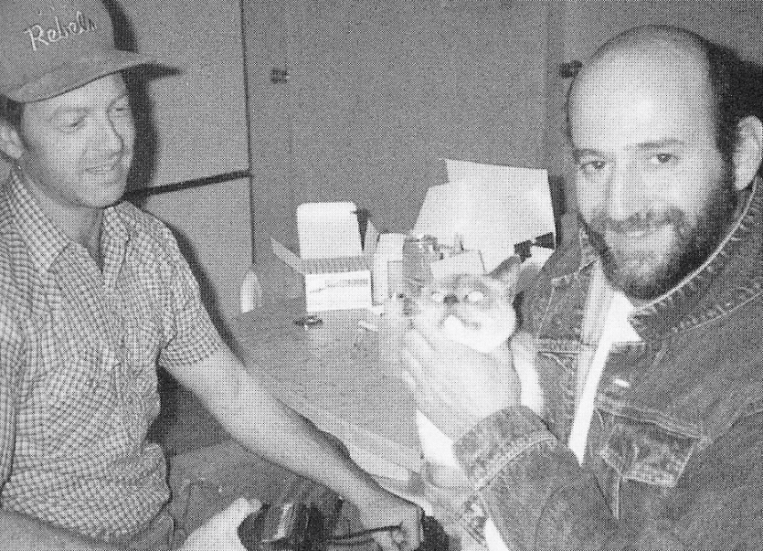 Vintage image of two men, one holding a cat