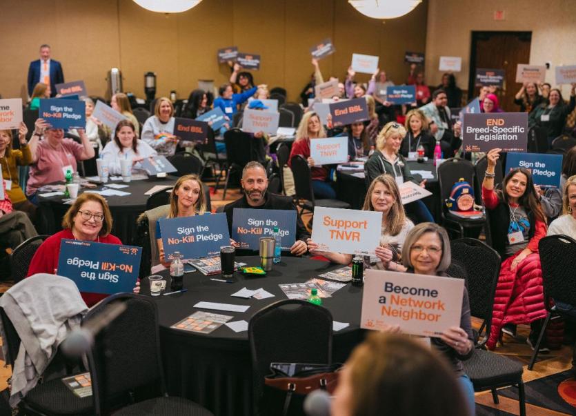 Attendees of Bring No-Kill Home Summits holding up signs.