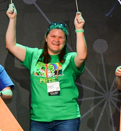 People on stage at the Best Friends National Conference holding flags and banners
